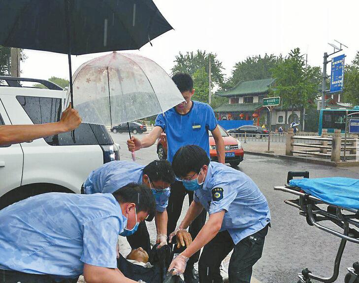 我们撑你！ 骑三轮老人晕倒，过路医生急救 俩路人撑伞守护，浑然不顾挨淋
